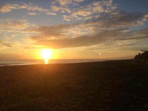 a sunset on the beach with the sun in the sky at Casa Grande at Pacuare Reserve in Matina