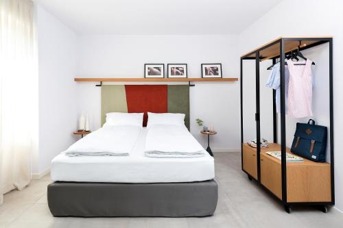 1 dormitorio con 1 cama con marco negro en BnBiz - Coworking Hotel, en Fiorenzuola dʼArda