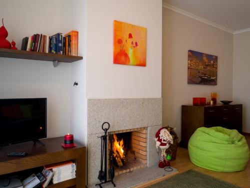 a living room with a fireplace and a green beanie at Madalena Beach Apartment by MP in Madalena