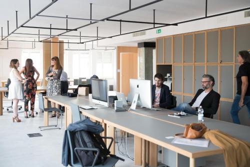 a group of people sitting at tables in an office at BnBiz - Coworking Hotel in Fiorenzuola dʼArda
