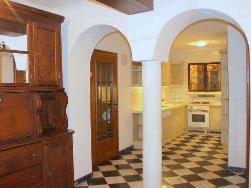 a kitchen with an arched doorway and a checkered floor at Barony Le Pergole holiday apartments Lugano in Lugano