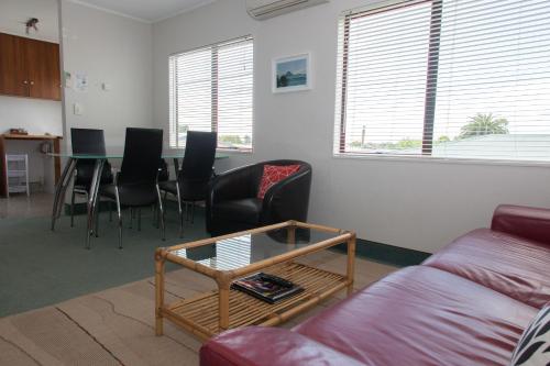 a living room with a couch and a table and chairs at Alton Lodge Motel in Whakatane