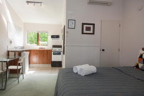 1 dormitorio con 1 cama con 2 toallas en Alton Lodge Motel, en Whakatane