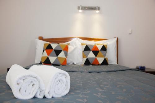 a bedroom with a bed with towels on it at Alton Lodge Motel in Whakatane