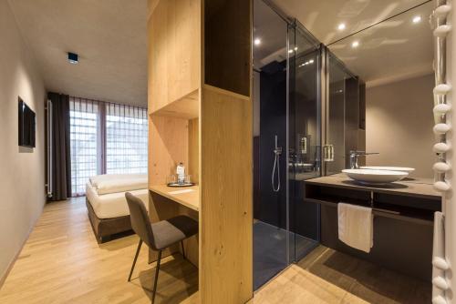 a bathroom with a sink and a shower at Ellgass Allgäu Hotel in Eglofs