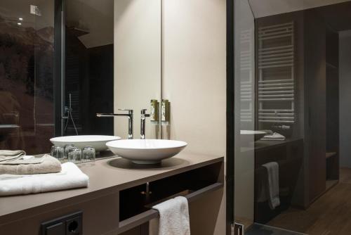 a bathroom with a sink and a mirror at Ellgass Allgäu Hotel in Eglofs