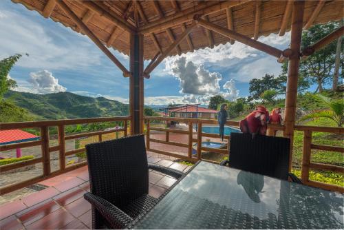 a table and chairs on a porch with a view at Finca Hotel Guayacundo in Vergara