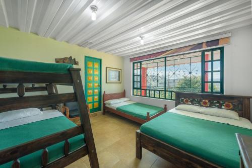 a bedroom with two bunk beds and windows at Finca Hotel Guayacundo in Vergara