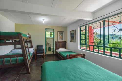 a bedroom with two bunk beds and a window at Finca Hotel Guayacundo in Vergara