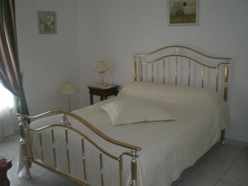 a bedroom with a white bed with a wooden frame at Maison Tobias in Bussy-Saint-Georges