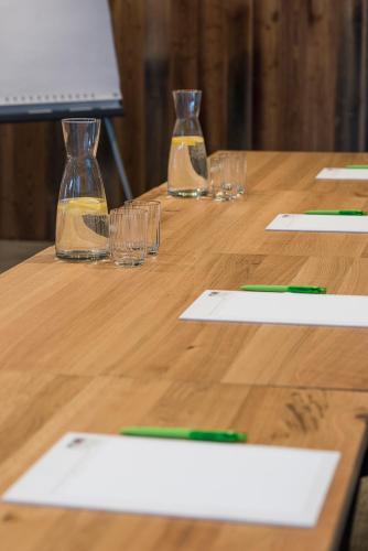 a wooden table with glasses and papers on it at Ellgass Allgäu Hotel in Eglofs