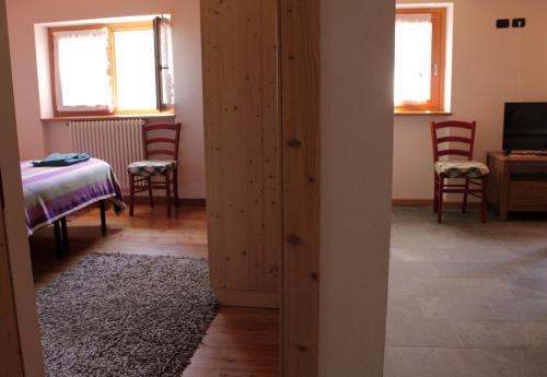 a room with a closet with a table and chairs at B&B Villa Dalegno in Temù