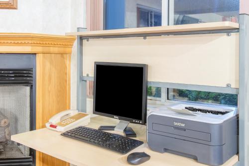 a desktop computer sitting on a desk with a printer at Super 8 by Wyndham West Middlesex/Sharon Area in West Middlesex