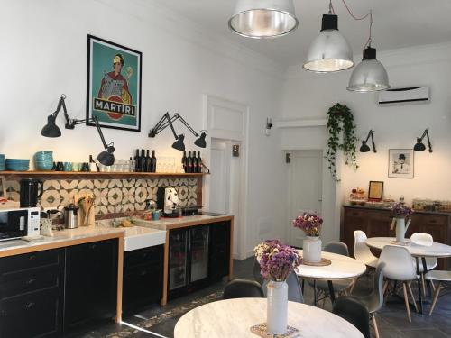 a kitchen with two tables and chairs and lights at Borgo Vergini Garden B&B in Naples