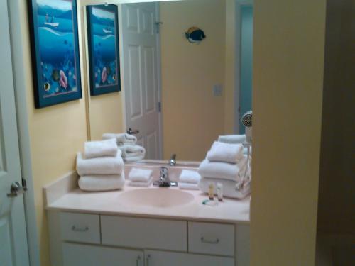 y baño con lavabo, espejo y toallas. en Ocean Walk Resort 910, en Daytona Beach