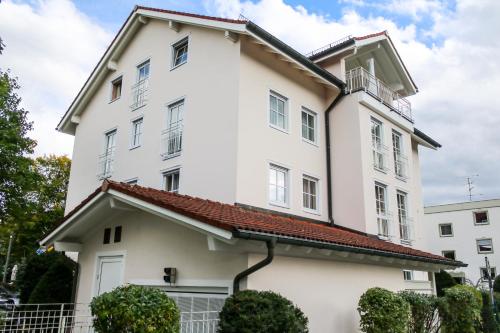 a white building with a red roof at Boutique Hotel Beckenlehner in Unterhaching