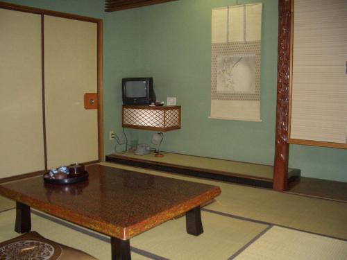 a room with a table and a tv on a wall at Murataya in Kanazawa