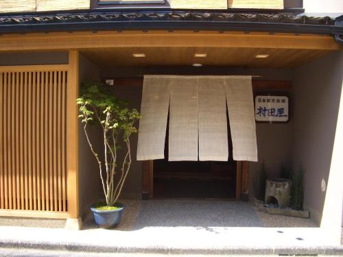 a building with a window and a plant in front of it at Murataya in Kanazawa
