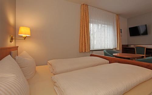 a hotel room with two beds and a television at Goldener Adler in Sulzheim