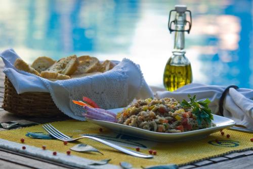 a plate of food on a table with a basket of bread at Vilangelim Eco-Pousada in Imbassai