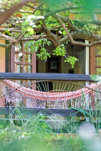 a hammock sitting on a bench under a tree at Vilangelim Eco-Pousada in Imbassai