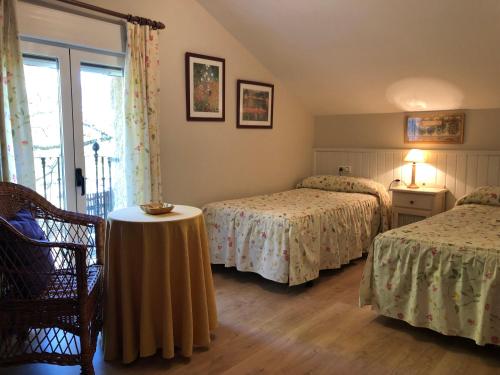 a bedroom with two beds and a table in a room at Casitas Del Huerto in La Alberca