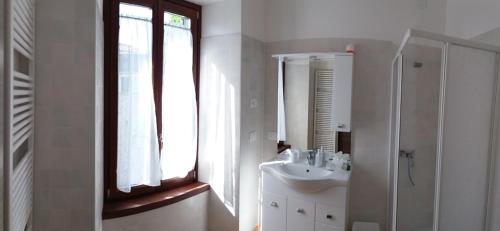 a white bathroom with a sink and a mirror at Carlito's Trattoria con alloggio in Vertemate