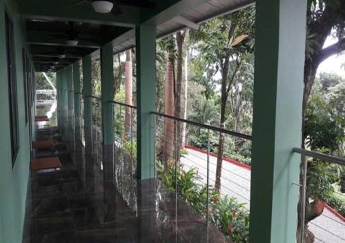 a balcony of a building with green columns and a sidewalk at Hotel Casa Conley Del Mar in Puerto Viejo