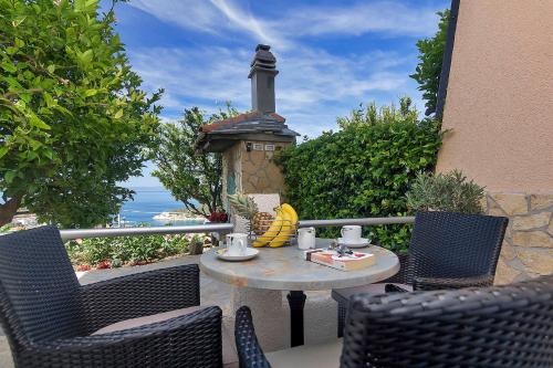 a table and chairs sitting on a patio with a fireplace at Villa Sukara in Makarska