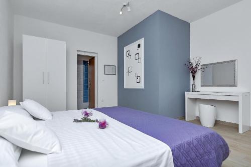 a bedroom with a large white bed with flowers on it at Villa Sukara in Makarska