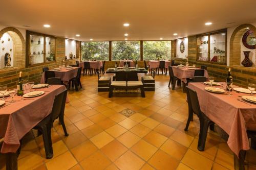a restaurant with tables and chairs in a room at Hotel Campestre La Periquera in Villa de Leyva