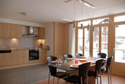 - une cuisine et une salle à manger avec une table et des chaises dans l'établissement Ferienwohnung Alte Bäckerei, à Mürren