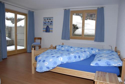 ミューレンにあるFerienwohnung Alte Bäckereiのベッドルーム1室(青い掛け布団付きのベッド1台付)