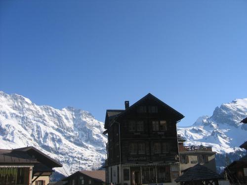 a building in front of a snowy mountain at Ferienwohnung Alte Bäckerei in Mürren