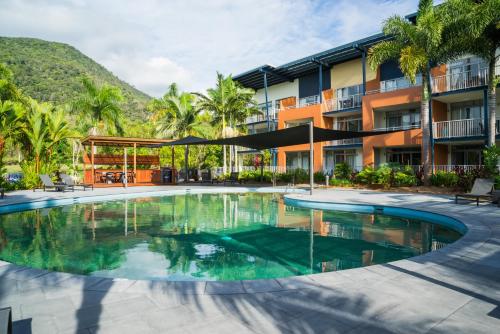 a swimming pool in front of a building at The Sebel Palm Cove in Palm Cove