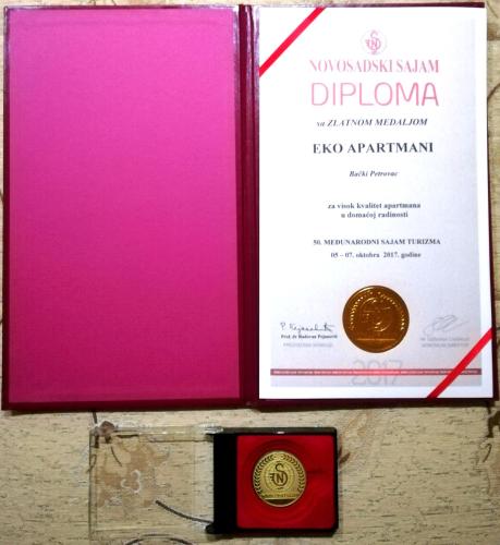 a book with a gold coin in a box at Eko Apartmani in Bački Petrovac