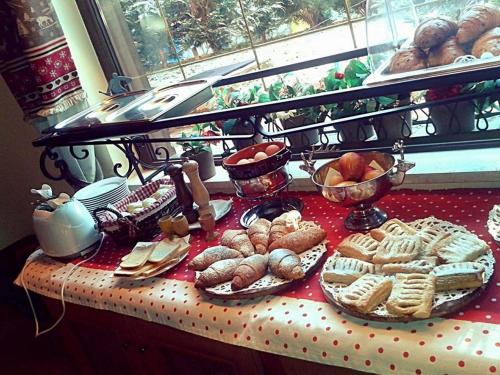 a table topped with different types of bread and pastries at Garnì Astoria Hotel & SPA in Roccaraso