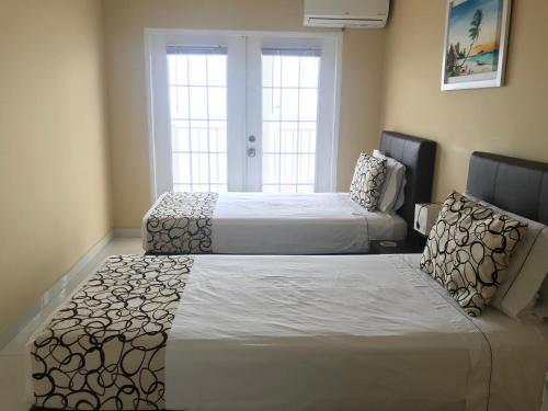 a bedroom with two beds and a couch and two windows at Haynes Cay View in San Andrés