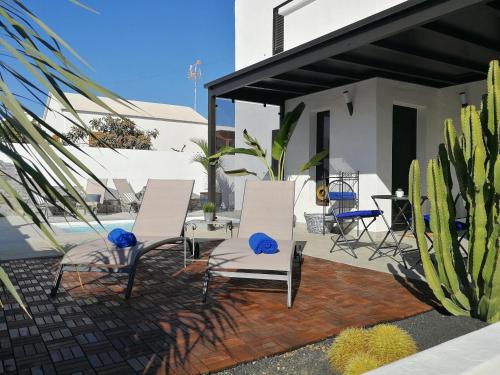 
a patio area with chairs, a table, and a patio umbrella at MAGMA Rooms Playa Honda in Playa Honda
