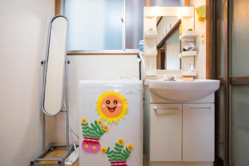 a refrigerator with a smiley face on it next to a sink at Aoi-Riverside Old Townhouse in Kyoto