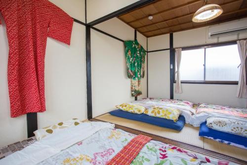 two beds in the corner of a room at Aoi-Riverside Old Townhouse in Kyoto