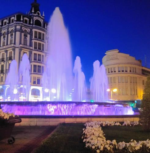 a water fountain in front of a building at night at Hostal Prada Borges in León