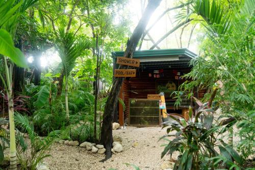 a sign in front of a building in a forest at Green Sanctuary Hotel in Nosara
