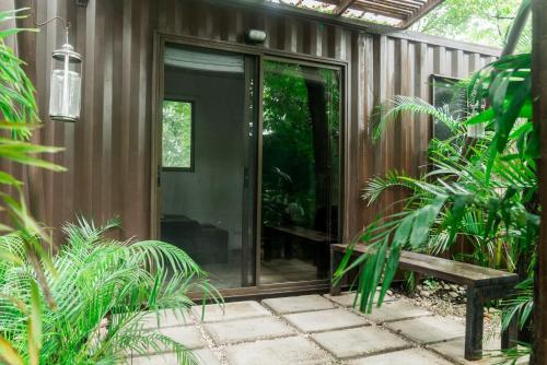 a sliding glass door on a house with plants at Green Sanctuary Hotel in Nosara