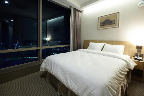 a bedroom with a large white bed and a window at Hotel Migliore Seoul in Seoul