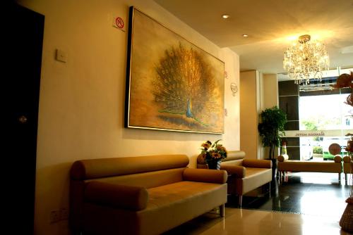 a living room with a couch and a painting on the wall at Mangga Boutique Hotel in Seri Kembangan