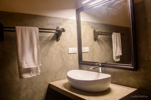 uma casa de banho com lavatório, espelho e toalhas em Breeze Villa Unawatuna em Galle