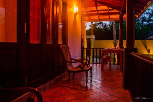 a porch with a chair and a table on a patio at Breeze Villa Unawatuna in Galle