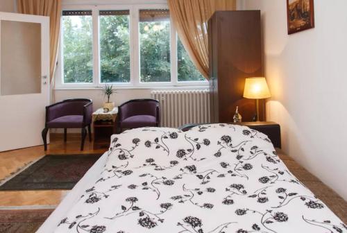 ein Schlafzimmer mit einem Bett mit einer schwarzen und weißen Decke in der Unterkunft Modern Cozy Apartment in Belgrad