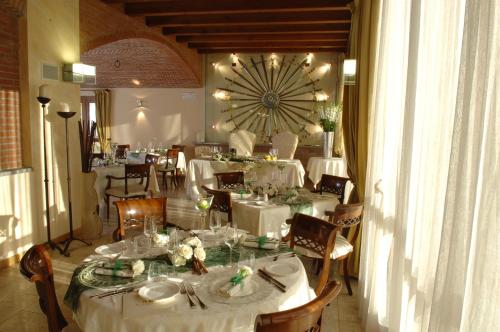 a dining room with white tables and a large clock at Hotel Fontana Santa in Grumello del Monte